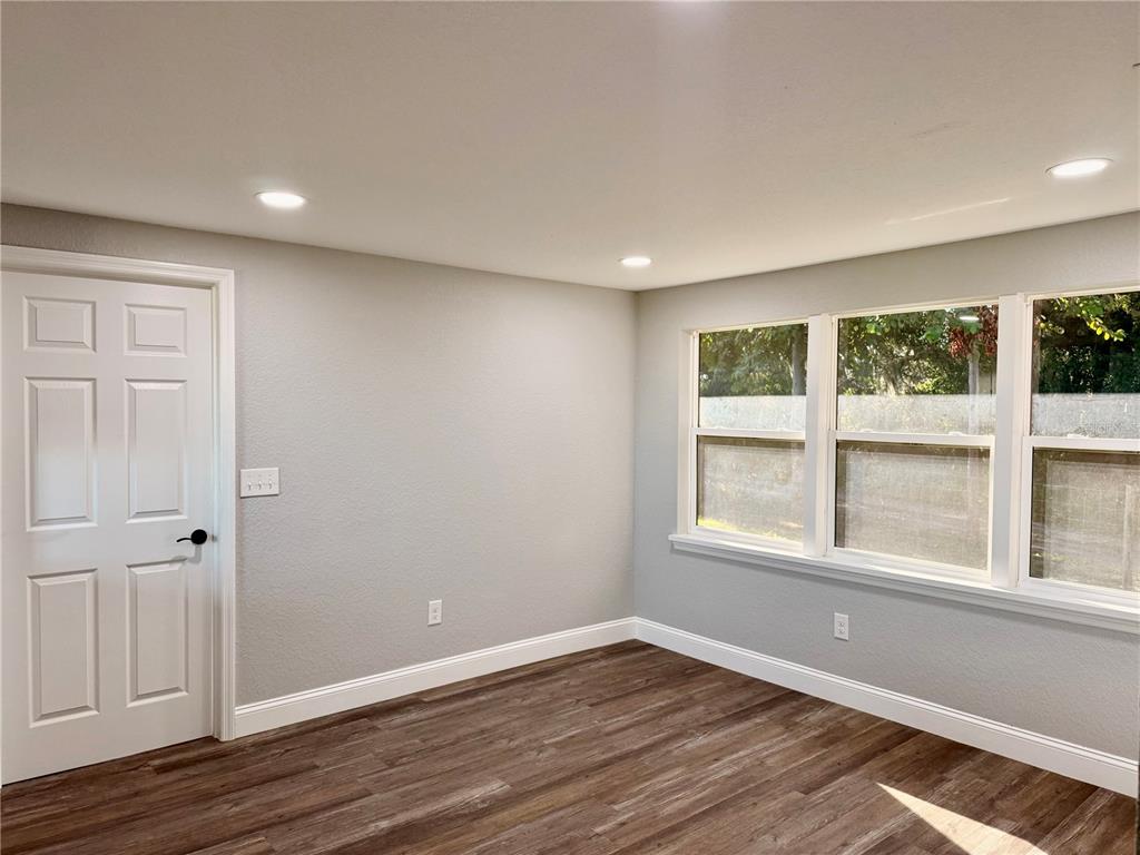 111 Water Tank Road Haines City, FL 33844 - Photo 11 of 48 an empty room with wooden floor and windows