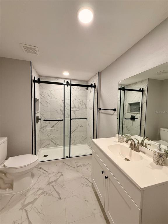 111 Water Tank Road Haines City, FL 33844 - Photo 18 of 48 a bathroom with a double vanity sink toilet mirror and shower