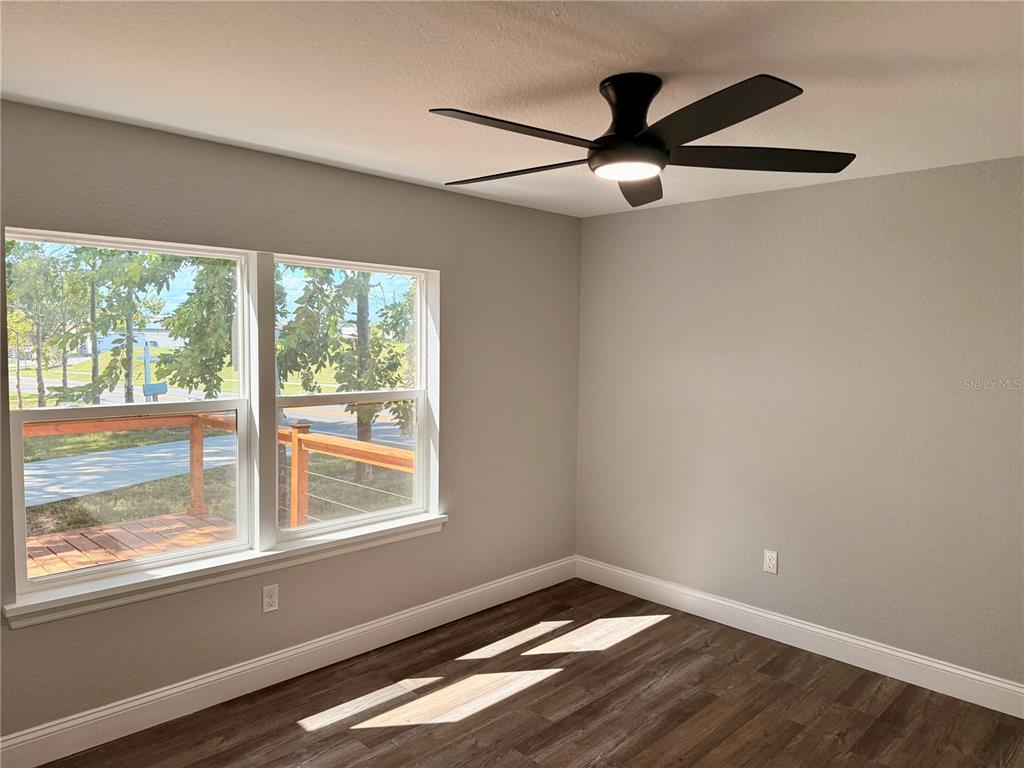 111 Water Tank Road Haines City, FL 33844 - Photo 20 of 48 a view of an empty room with wooden floor and a window
