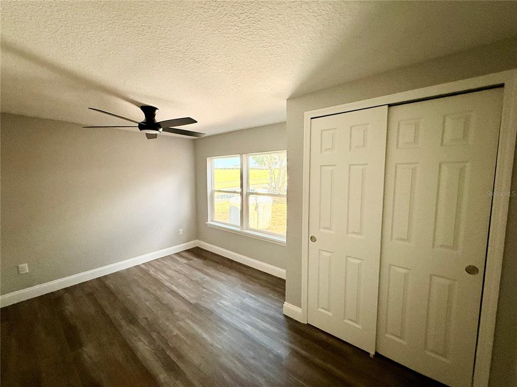 111 Water Tank Road Haines City, FL 33844 - Photo 24 of 48 an empty room with wooden floor closet and windows