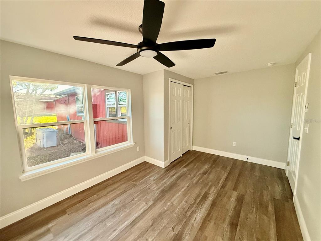 111 Water Tank Road Haines City, FL 33844 - Photo 25 of 48 a view of empty room with wooden floor and fan
