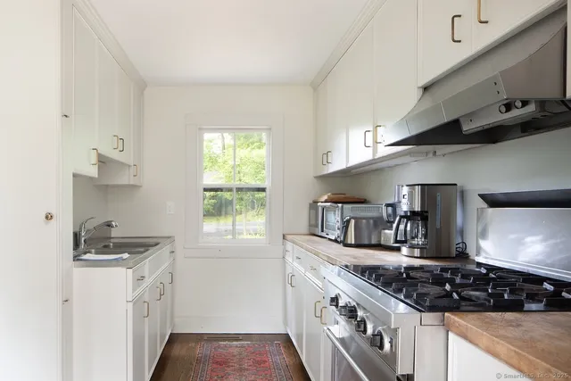 a kitchen with stainless steel appliances granite countertop a sink a stove and a refrigerator