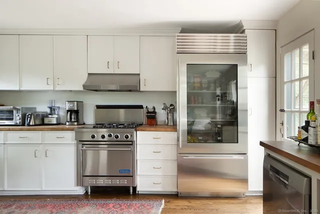 a kitchen with white cabinets and appliances