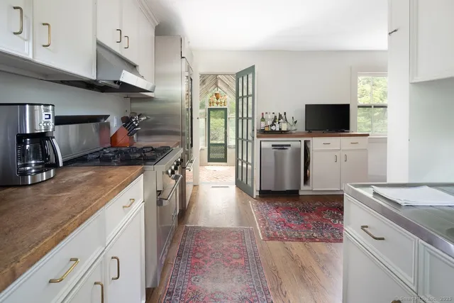 a kitchen with white cabinets and appliances