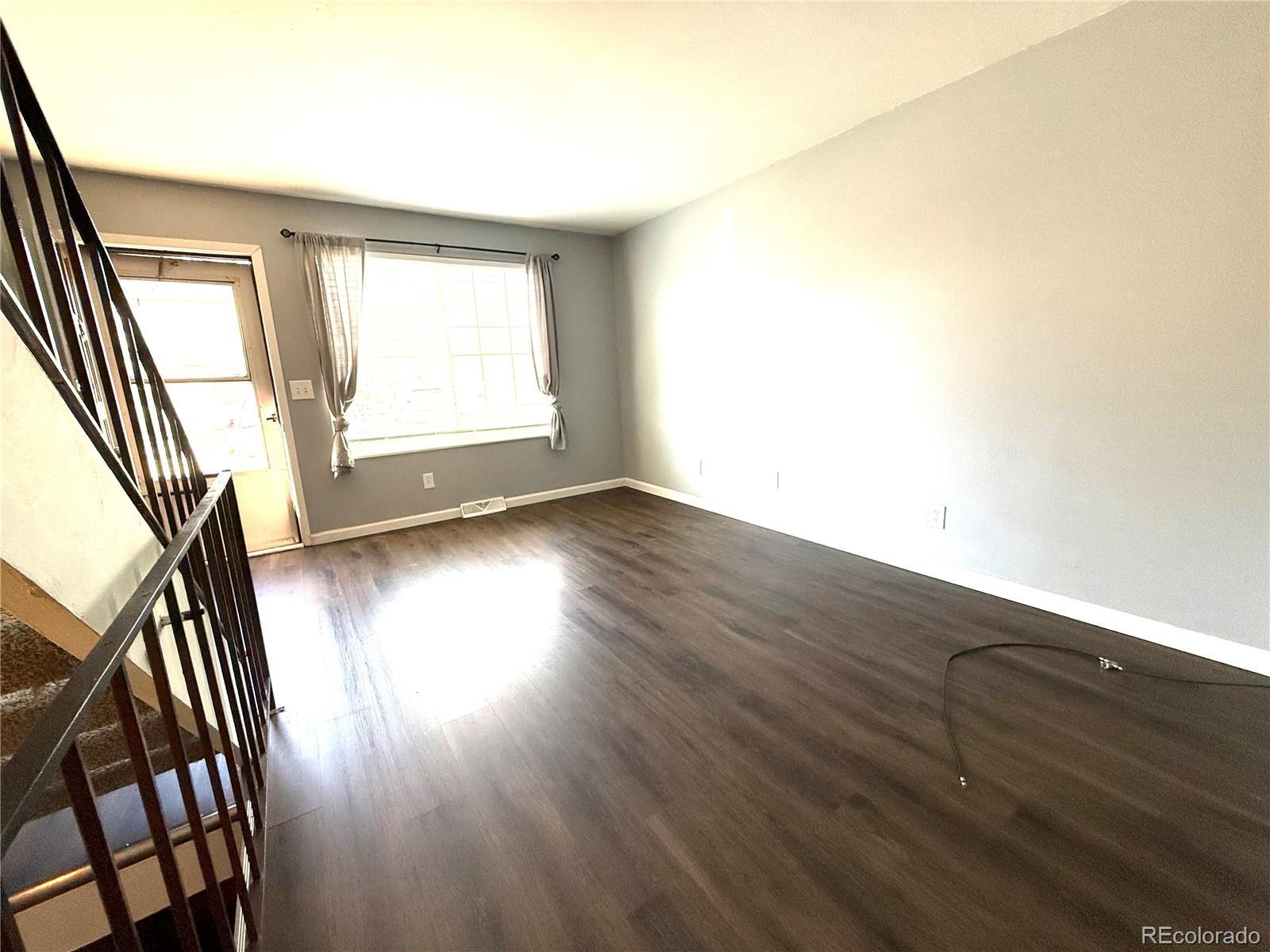 8905 Field Street, Unit 89 Broomfield, CO 80021 - Photo 3 of 18 an empty room with wooden floor and windows
