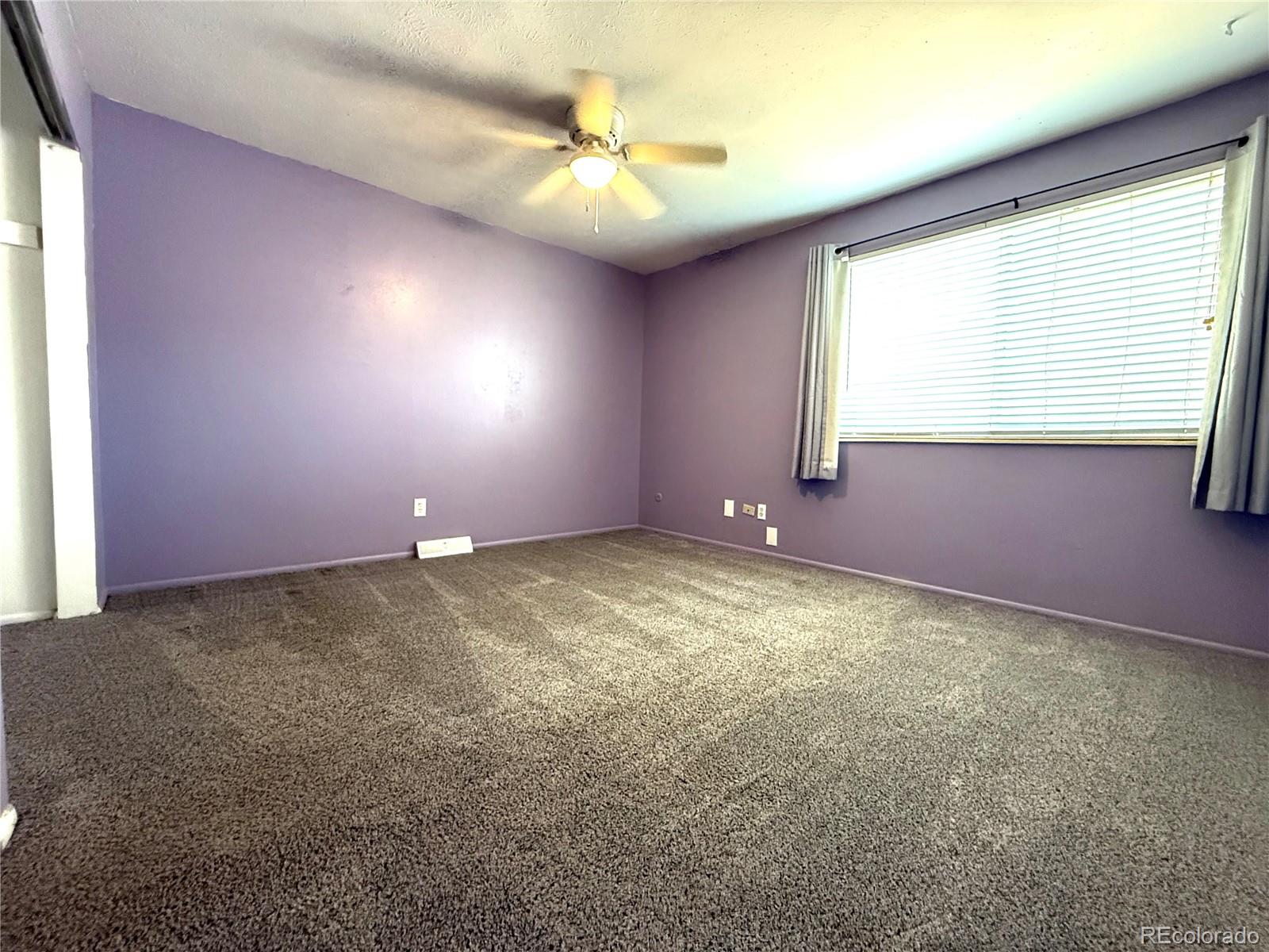 8905 Field Street, Unit 89 Broomfield, CO 80021 - Photo 10 of 18 an empty room with windows and chandelier fan