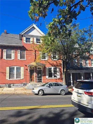 a front view of a house with a garden and swimming pool