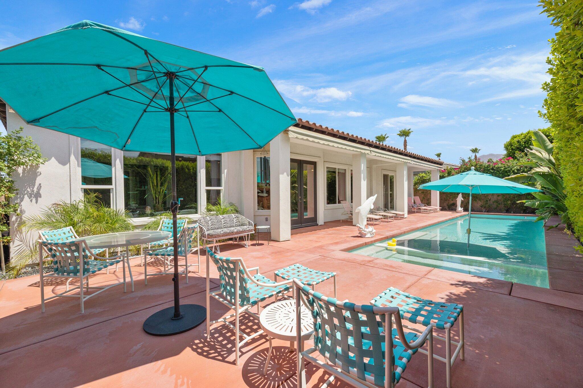 a patio table and chairs under an umbrella
