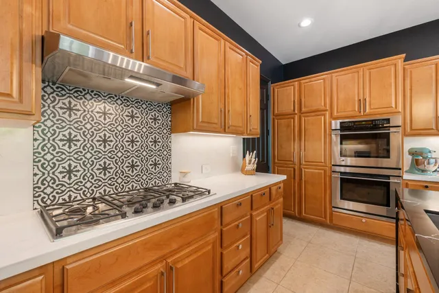 a kitchen with stainless steel appliances granite countertop a refrigerator and a stove