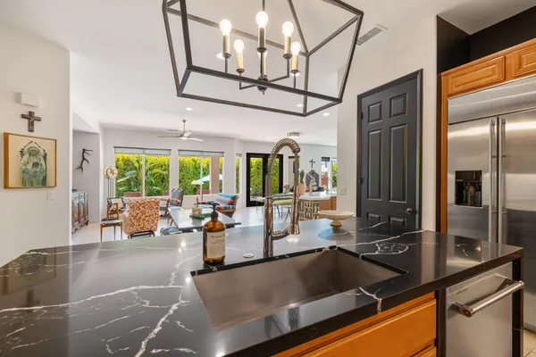 a kitchen with stainless steel appliances granite countertop a sink and a refrigerator