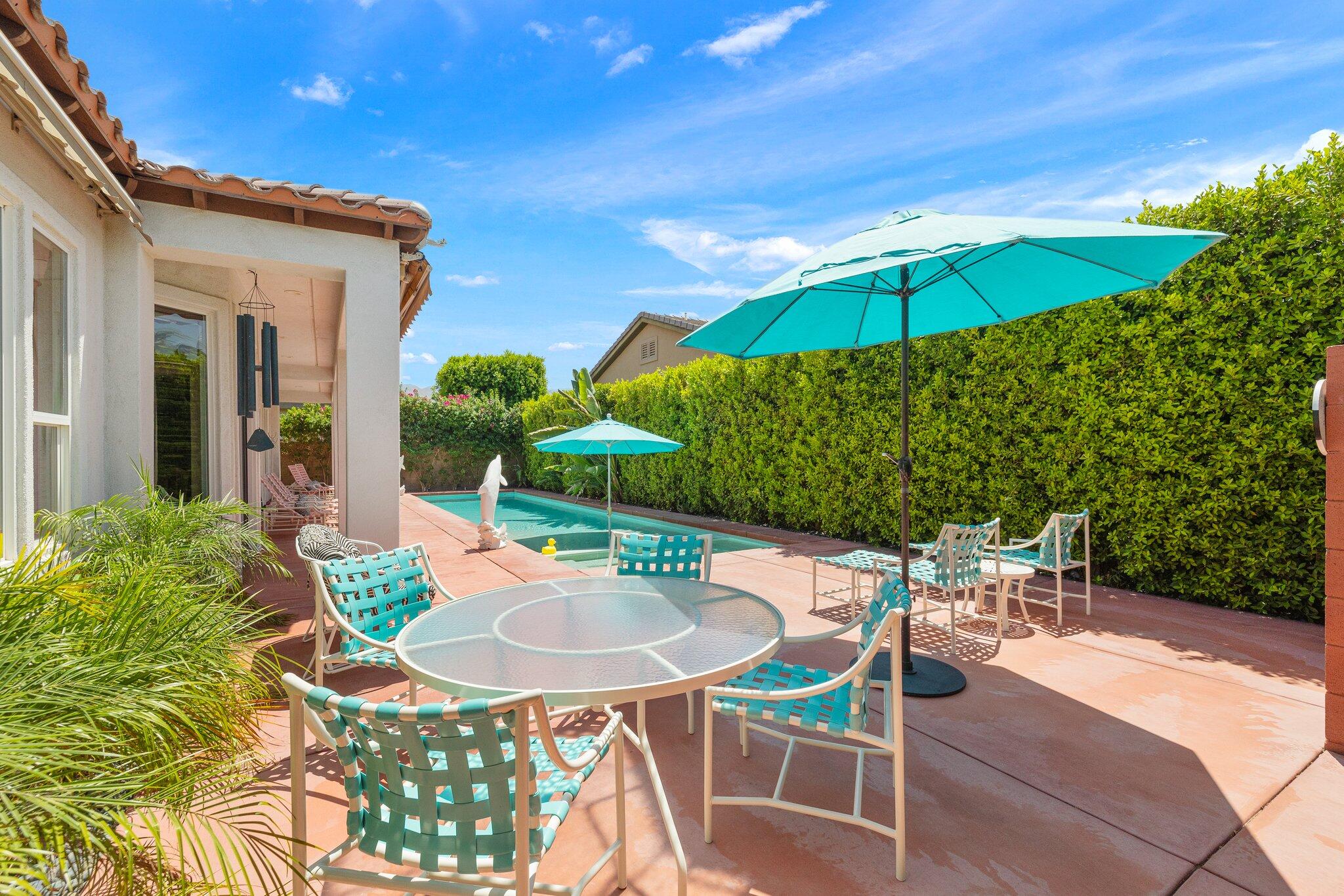 61185 Soaptree Drive La Quinta, CA 92253 - Photo 35 of 51 a patio with a table and chairs under an umbrella
