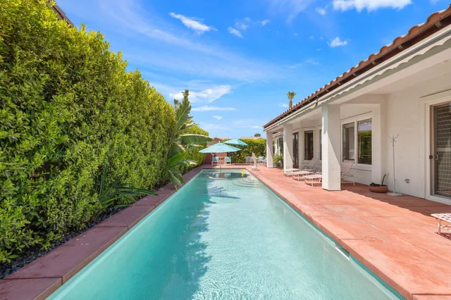 a view of a house with backyard patio and swimming pool