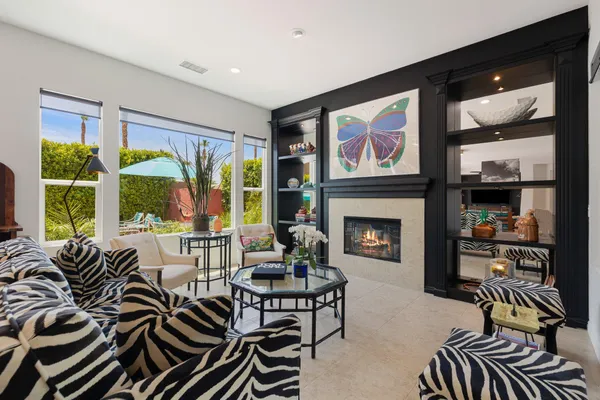 a living room with furniture fireplace and large windows