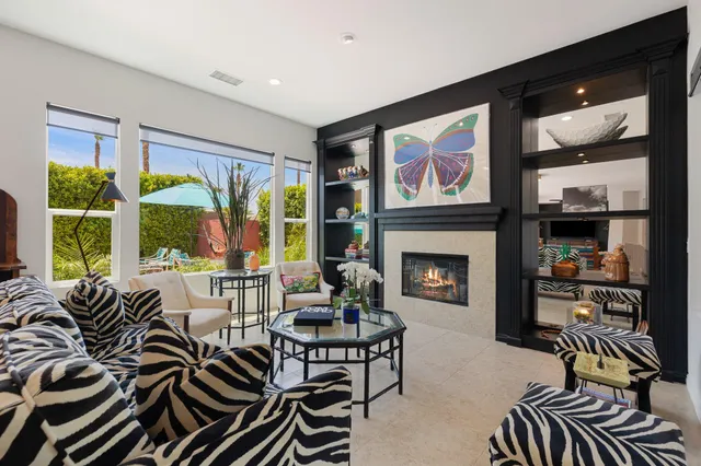 a living room with furniture fireplace and large windows