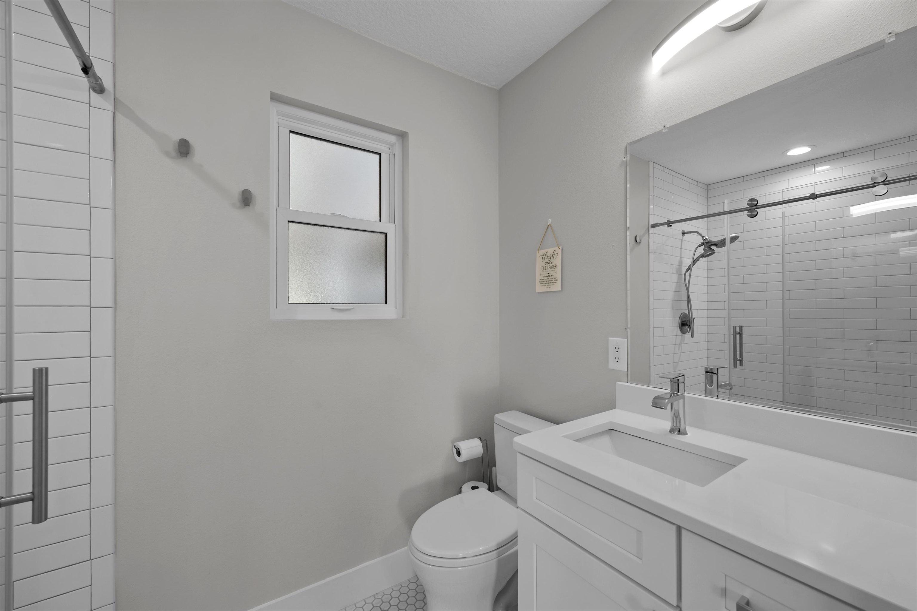 5425 B Windantide Road St. Augustine, FL 32080 - Photo 26 of 34 a bathroom with a sink toilet vanity and shower