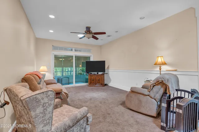 a living room with furniture ceiling fan and a flat screen tv