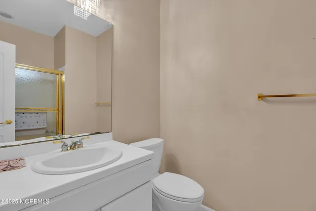 a bathroom with a toilet a sink a mirror and vanity