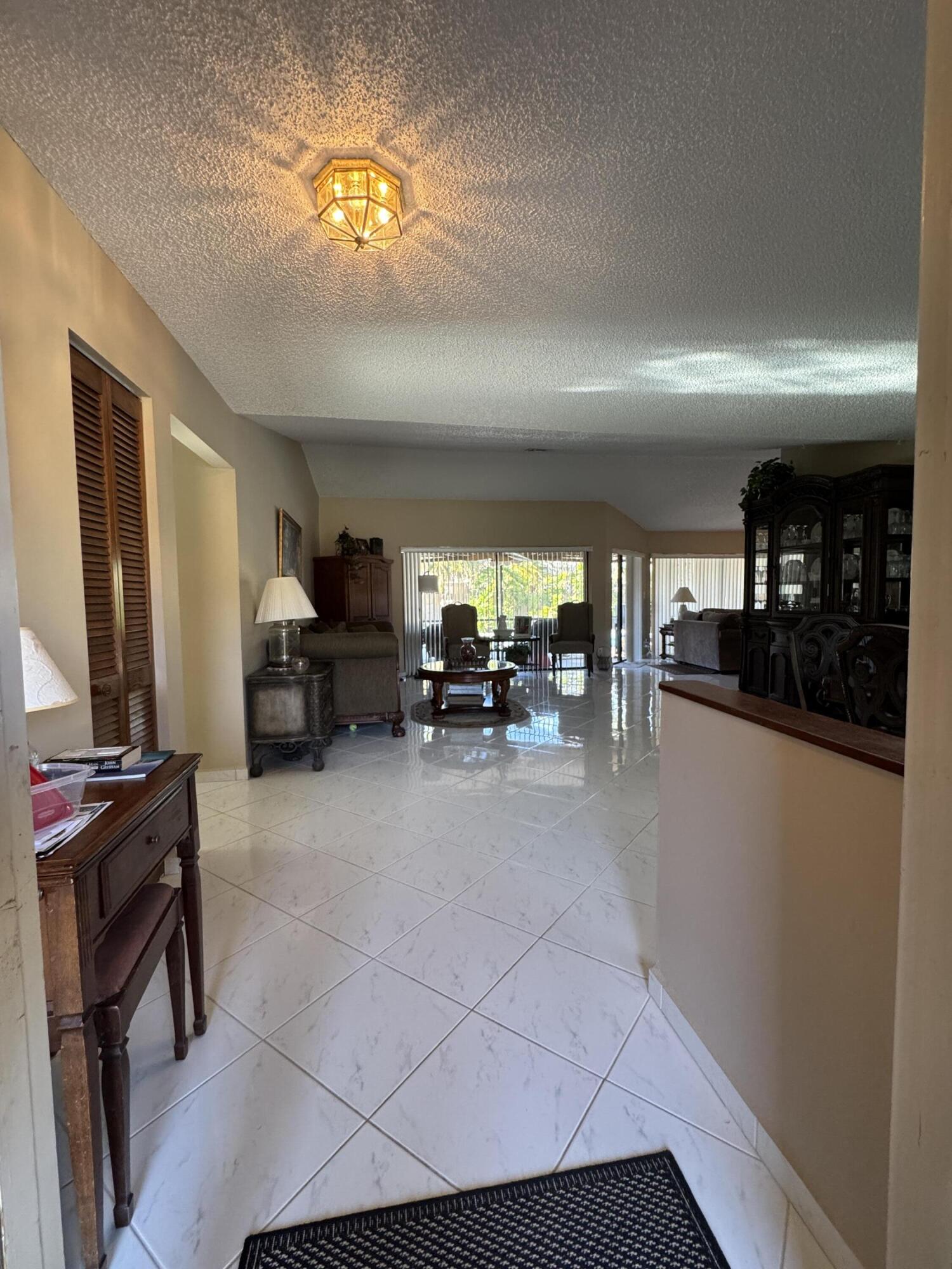 21149 Shady Vista Lane Boca Raton, FL 33428 - Photo 11 of 32 a living room with furniture and a chandelier