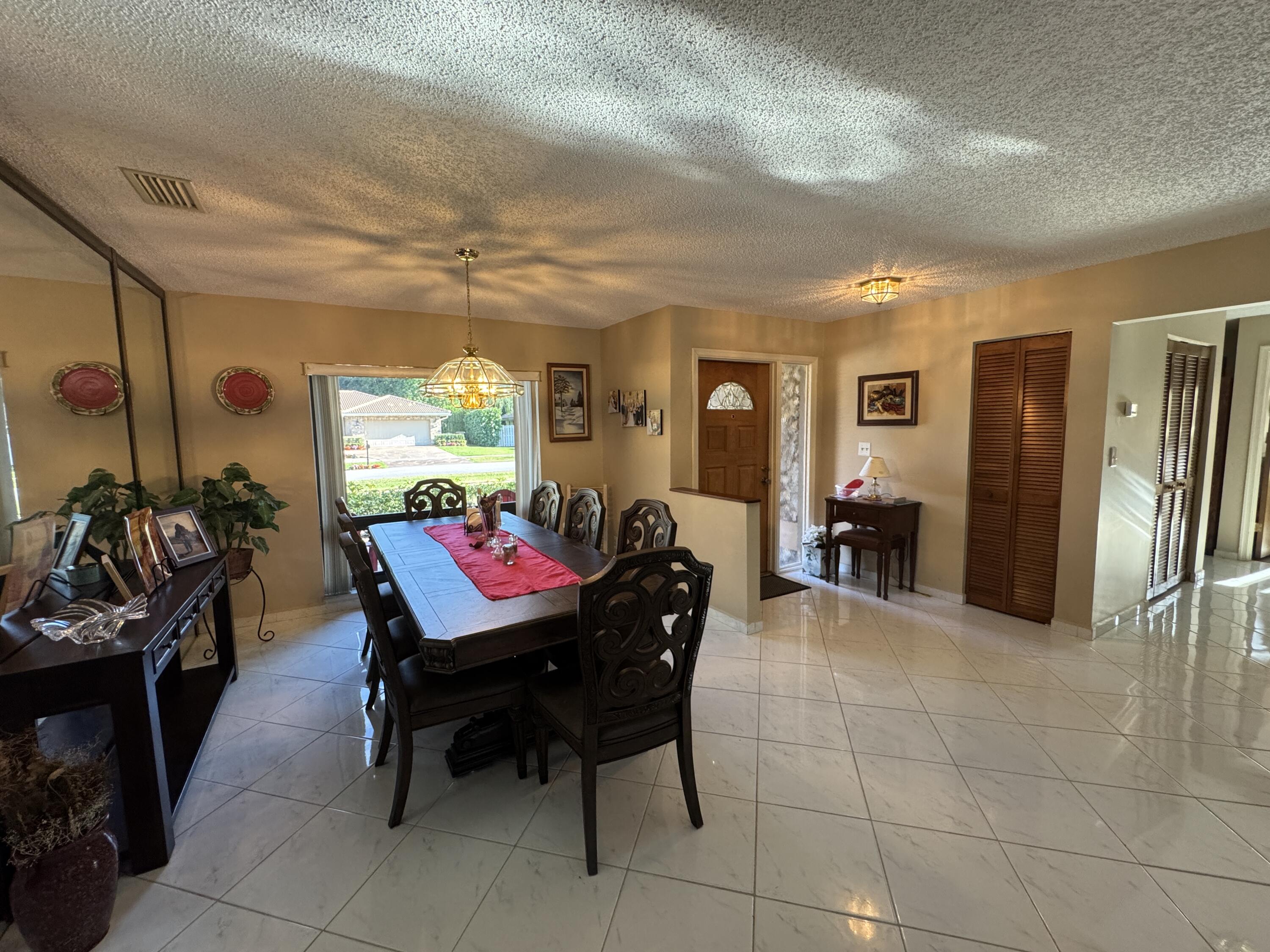 21149 Shady Vista Lane Boca Raton, FL 33428 - Photo 13 of 32 a living room with furniture a dining table and a refrigerator