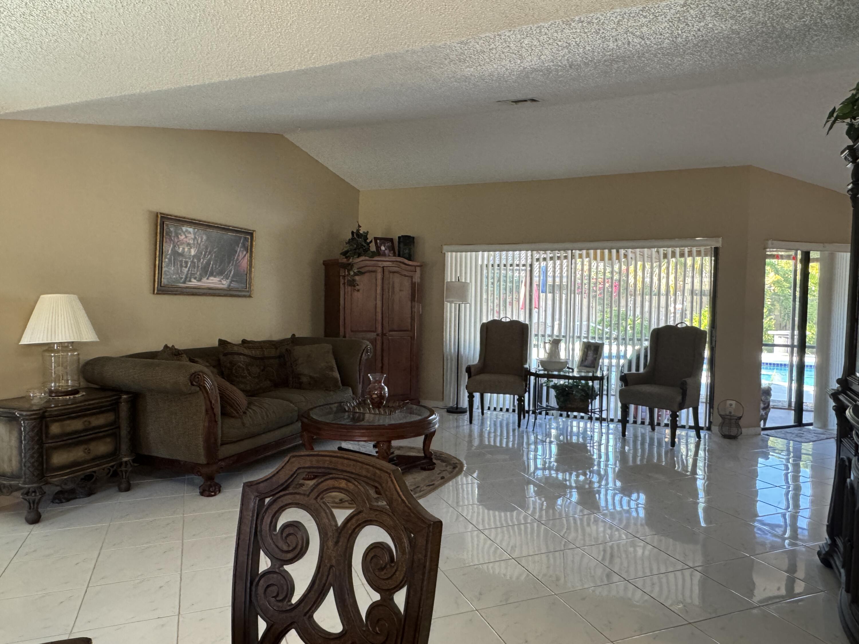 21149 Shady Vista Lane Boca Raton, FL 33428 - Photo 15 of 32 a living room with furniture a lamp and a dining table