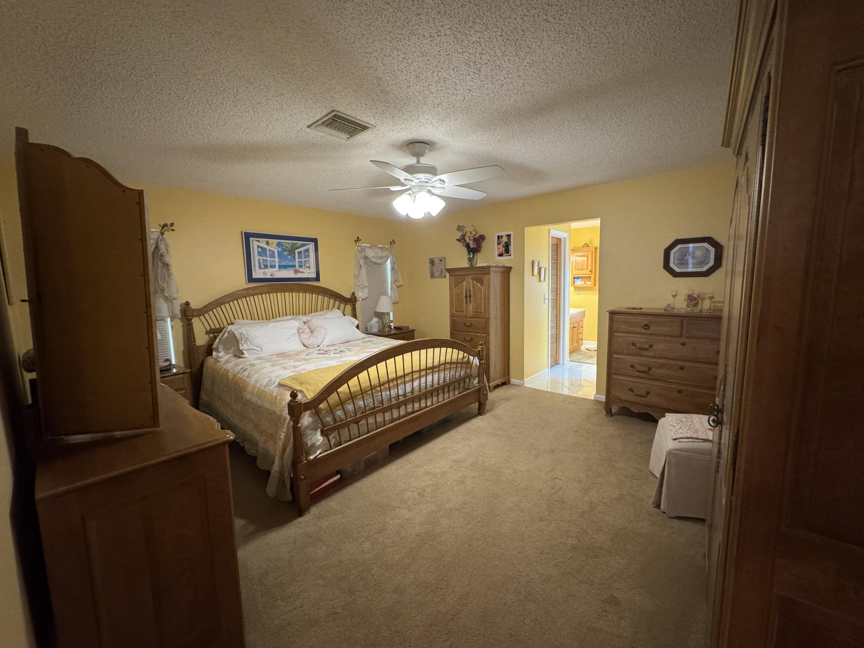 21149 Shady Vista Lane Boca Raton, FL 33428 - Photo 22 of 32 a bedroom with a bed and a flat tv screen on dresser
