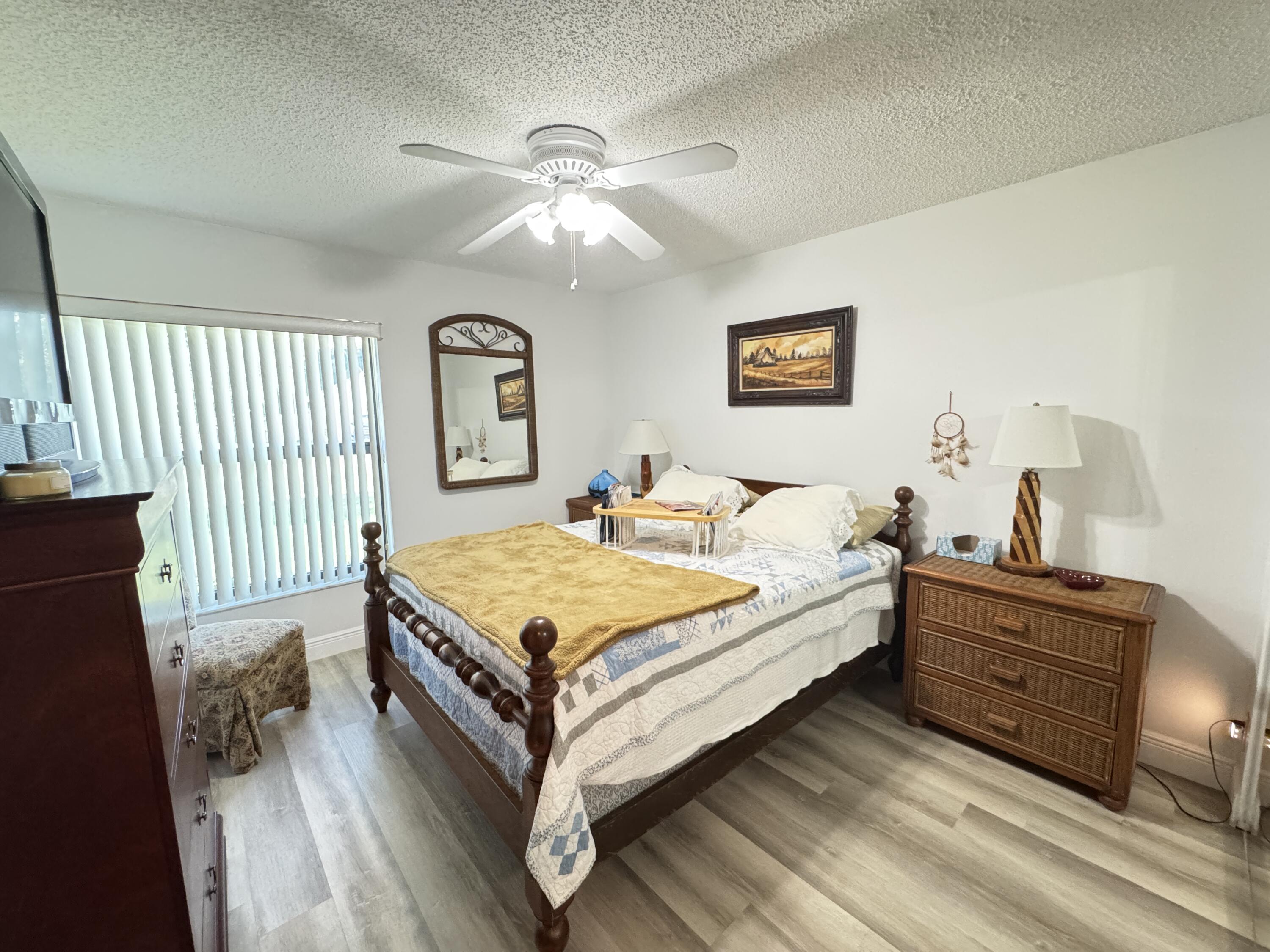 21149 Shady Vista Lane Boca Raton, FL 33428 - Photo 26 of 32 a spacious bedroom with a bed and a chandelier