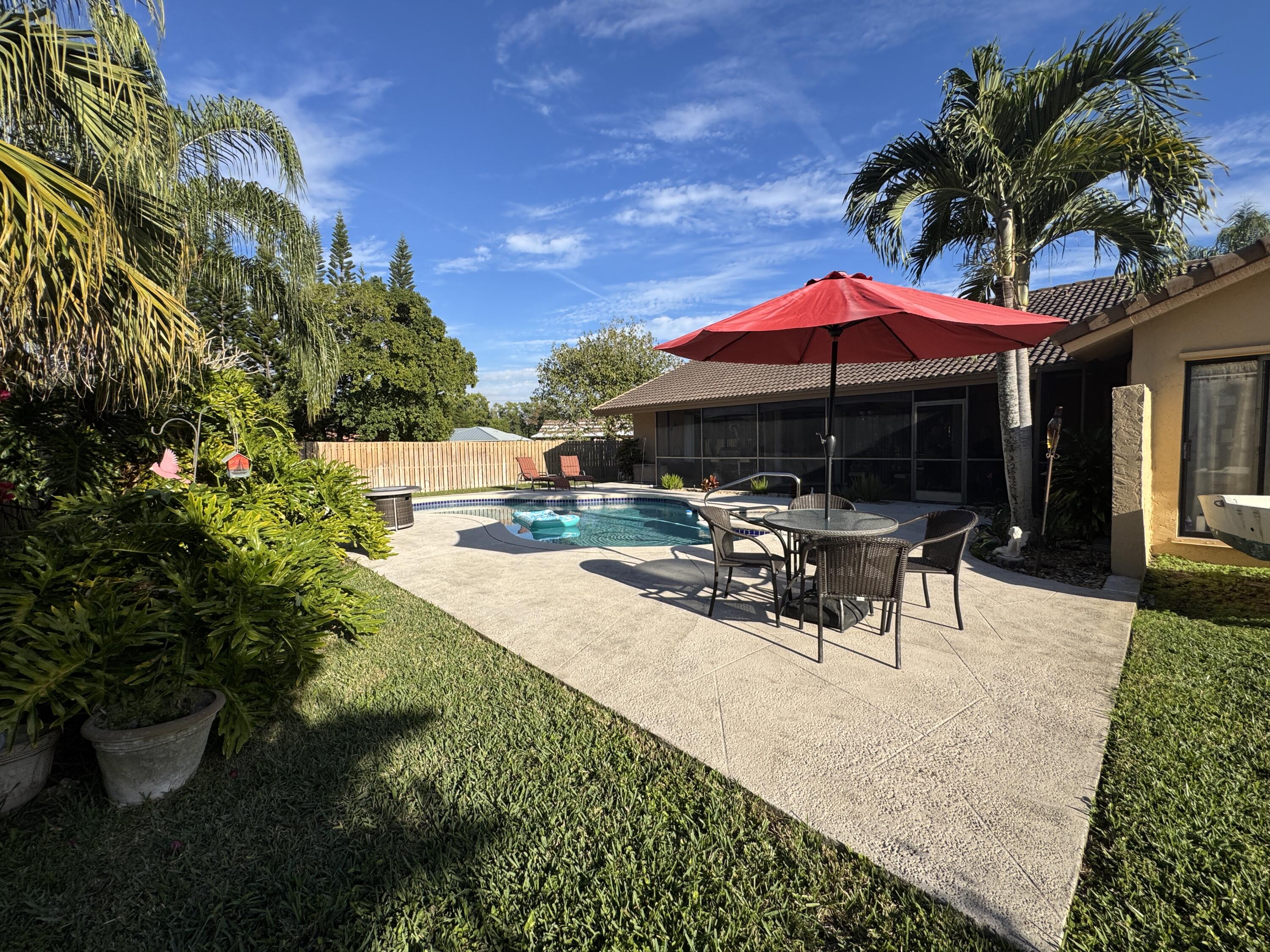 21149 Shady Vista Lane Boca Raton, FL 33428 - Photo 7 of 32 a view of a patio with a table and chairs under an umbrella