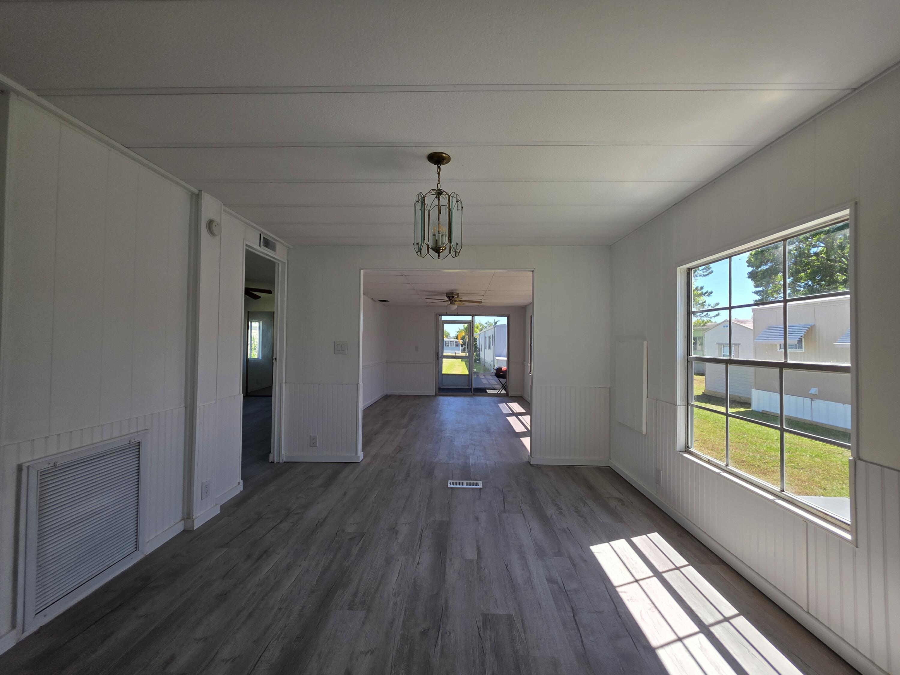 8 Del Sol Port St. Lucie, FL 34952 - Photo 11 of 26 a view of empty room with wooden floor and fan