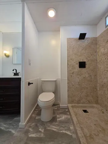 a bathroom with a toilet and a shower