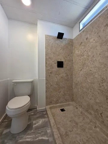 a bathroom with a toilet and a shower