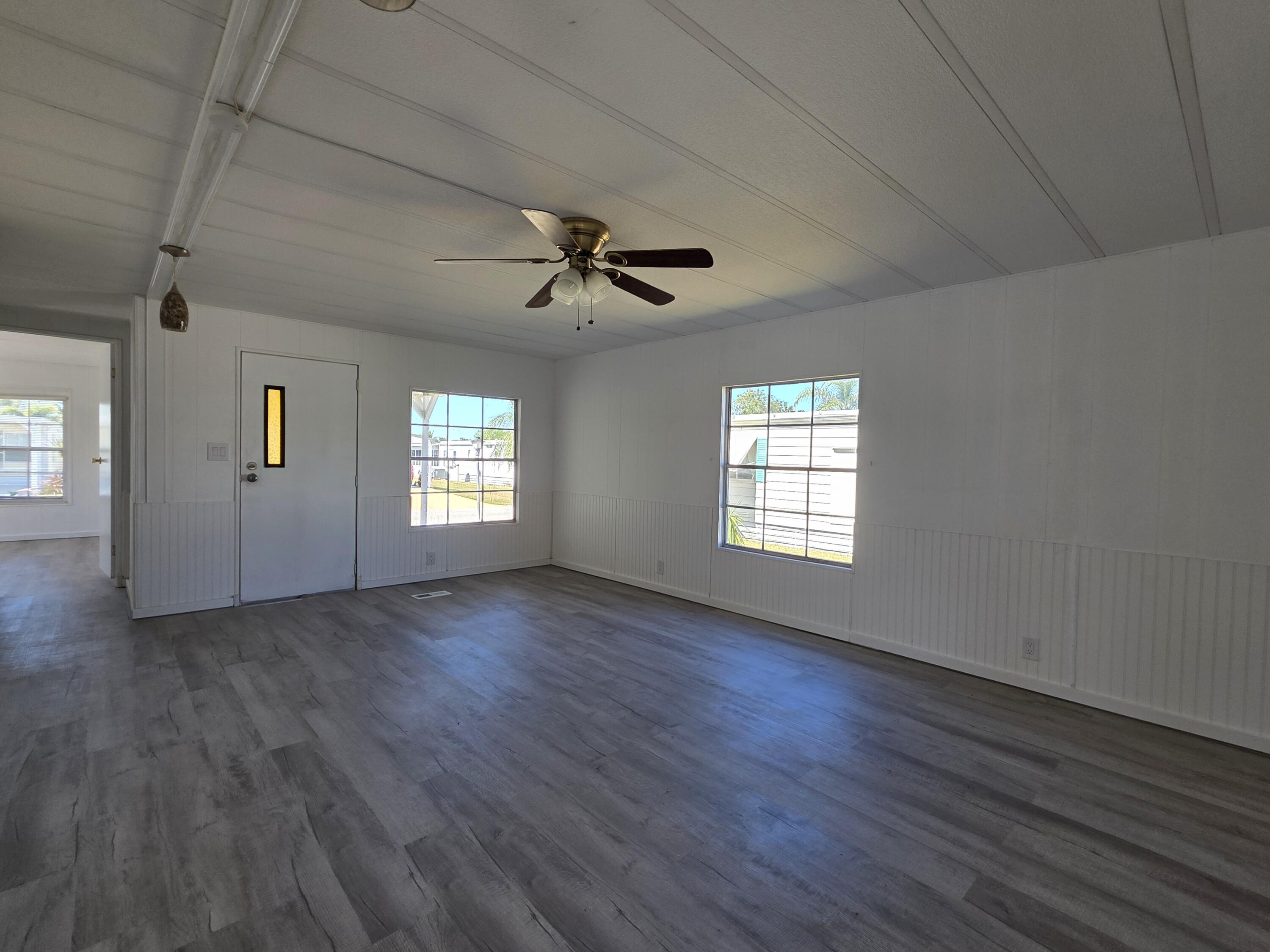 8 Del Sol Port St. Lucie, FL 34952 - Photo 6 of 26 a view of an empty room with a window and wooden floor