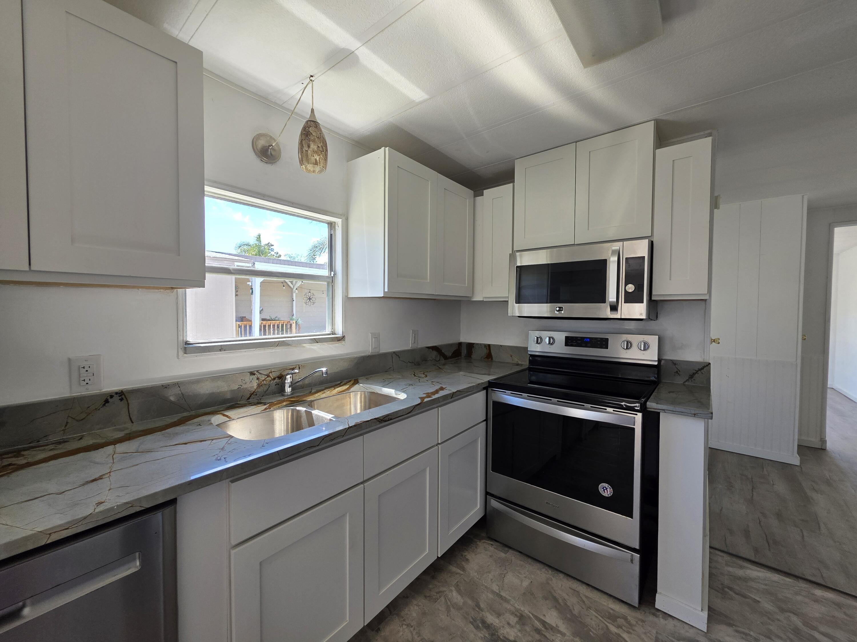 8 Del Sol Port St. Lucie, FL 34952 - Photo 7 of 26 a kitchen with a sink stove and microwave