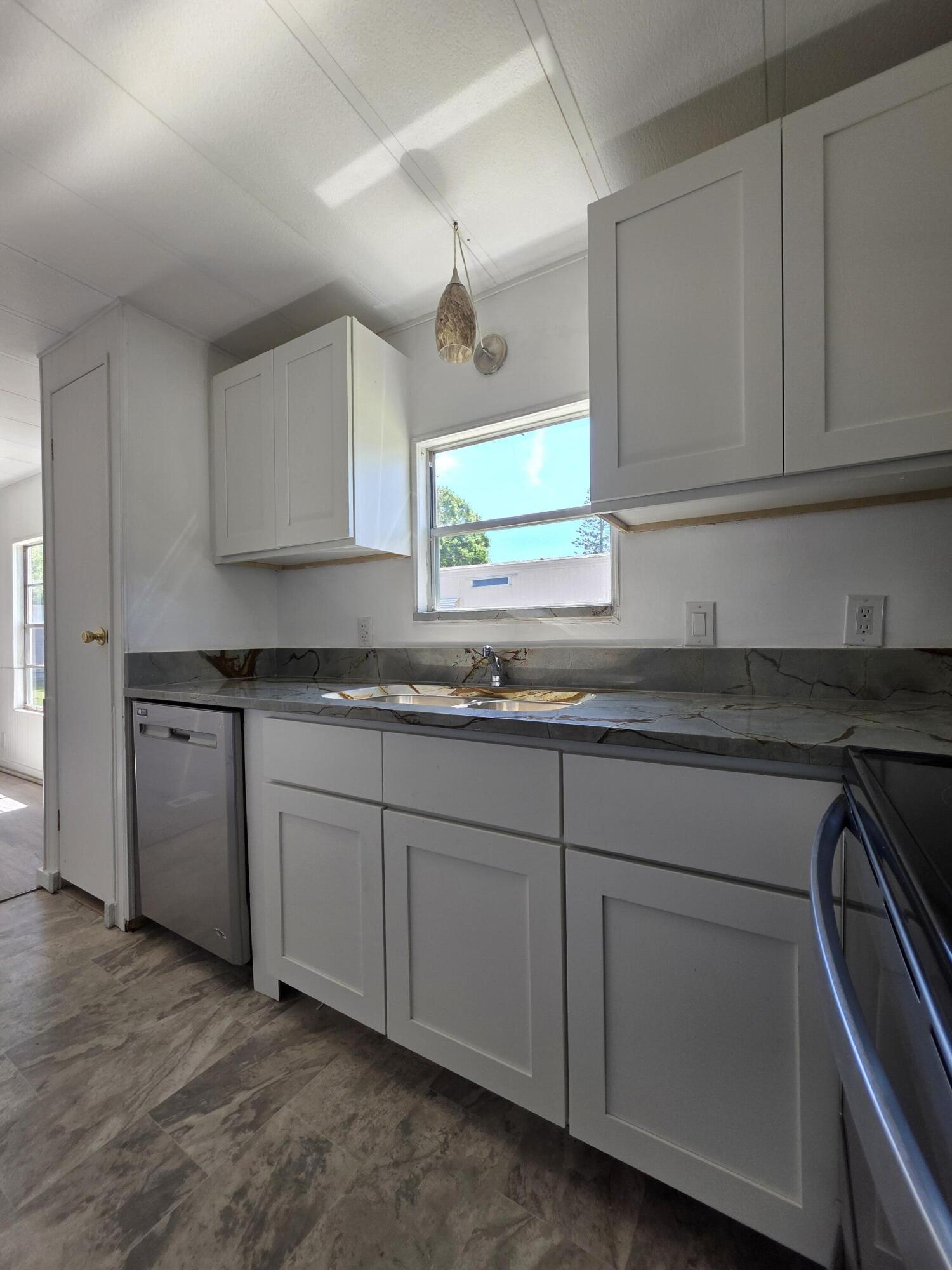 8 Del Sol Port St. Lucie, FL 34952 - Photo 8 of 26 a kitchen with granite countertop white cabinets and a sink