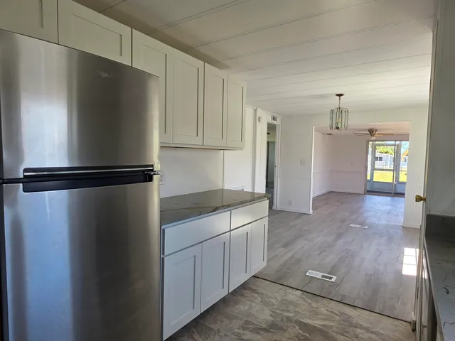 a kitchen with kitchen island wooden cabinets and refrigerator