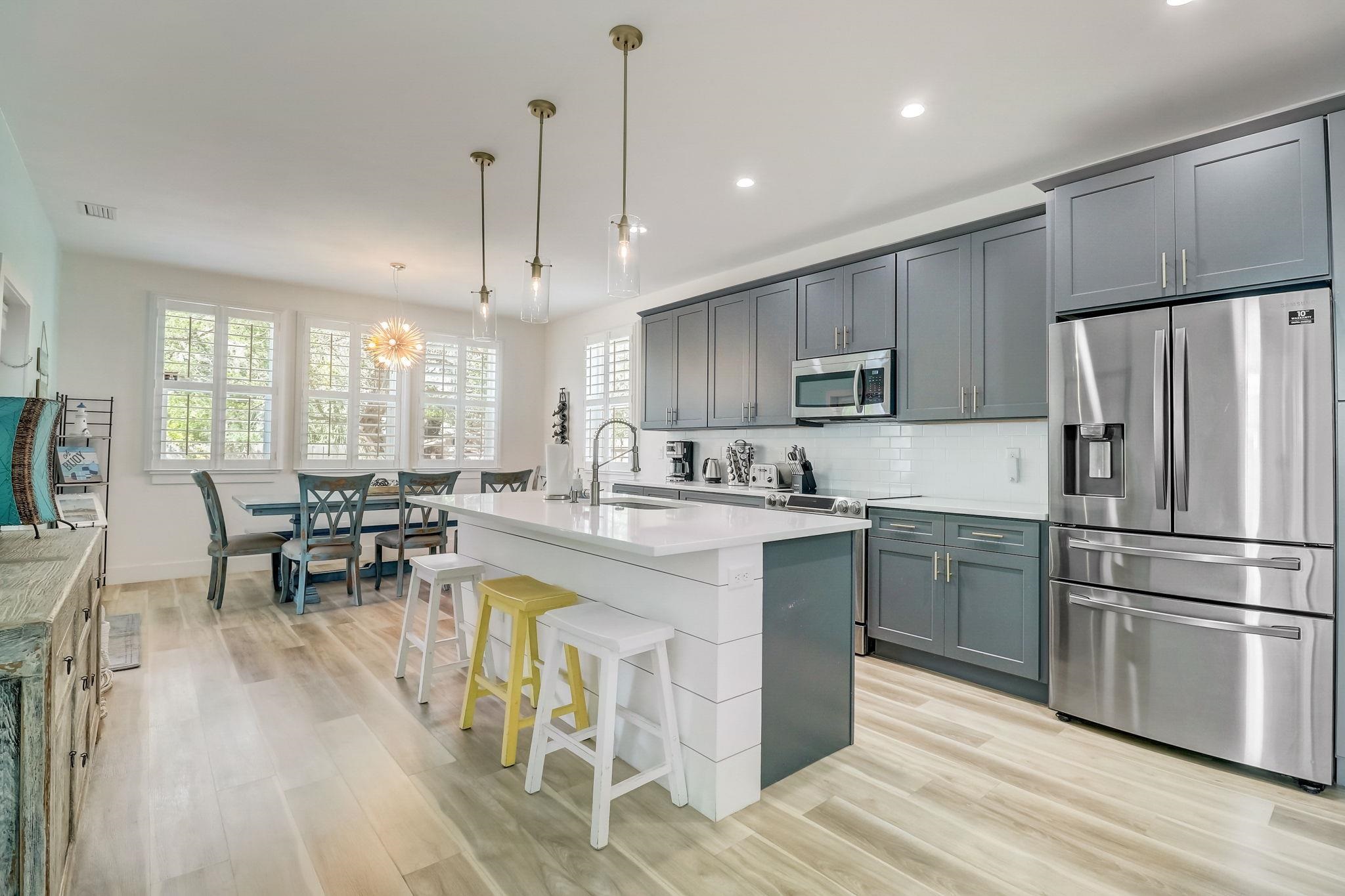 45 Menendez Road St. Augustine, FL 32080 - Photo 8 of 36 a kitchen with stainless steel appliances granite countertop a refrigerator a stove a sink dishwasher a dining table and chairs with wooden floor