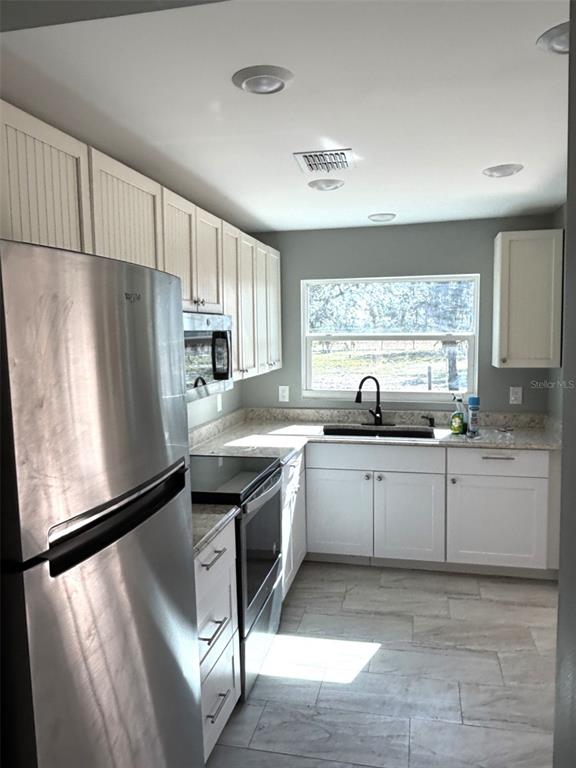316 Brooks Road Frostproof, FL 33843 - Photo 5 of 11 a kitchen with stainless steel appliances granite countertop a refrigerator sink and stove