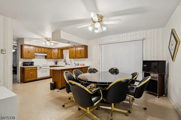 a kitchen with a sink chairs and refrigerator