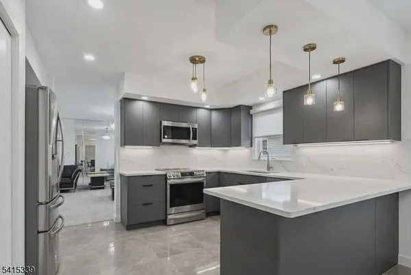 a kitchen with stainless steel appliances granite countertop a sink a stove and a refrigerator
