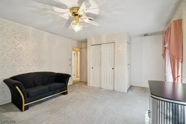 a living room with furniture and a ceiling fan