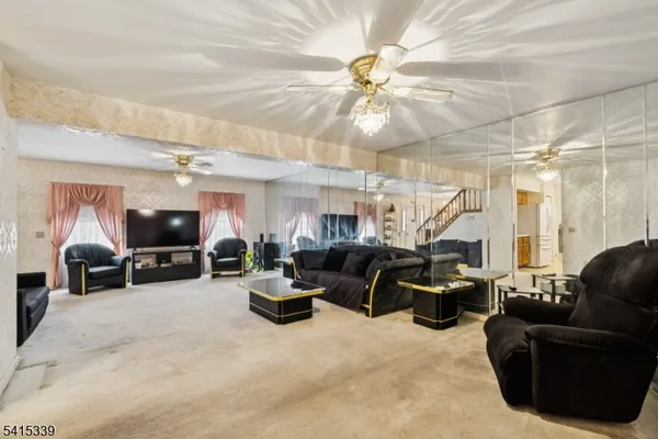 a living room with furniture a flat screen tv and a large window
