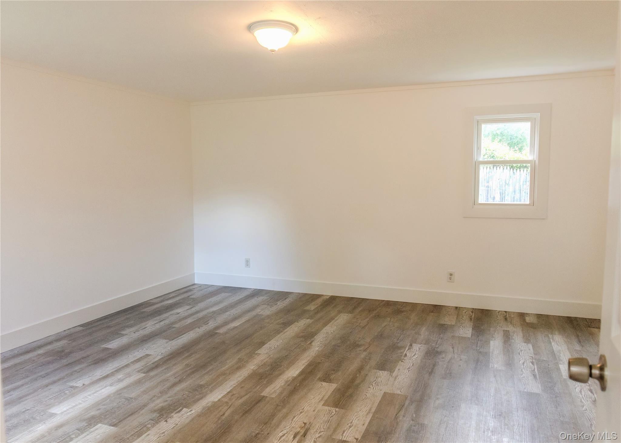 23 Lucille Road Carmel, NY 10512 - Photo 18 of 44 an empty room with wooden floor and windows