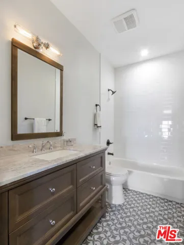 a bathroom with a double vanity sink mirror and toilet