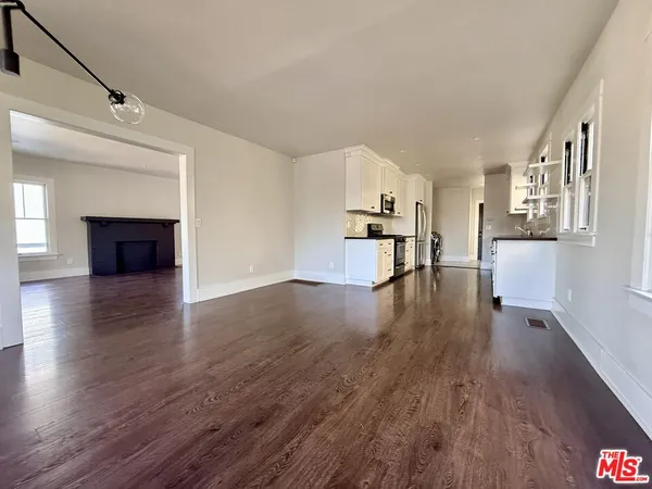 a view of empty room with wooden floor and fireplace