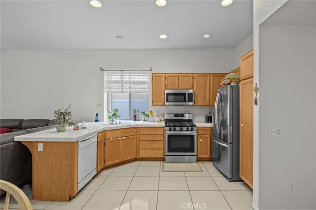 a kitchen with stainless steel appliances granite countertop a sink stove refrigerator and microwave