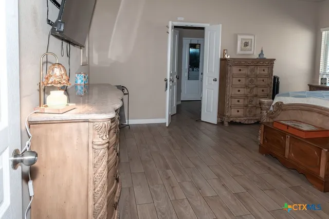 a kitchen with stainless steel appliances granite countertop a refrigerator a sink a stove and white cabinets with wooden floor