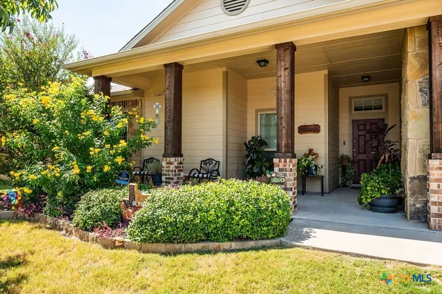 a view of a patio with table and chairs under an umbrella