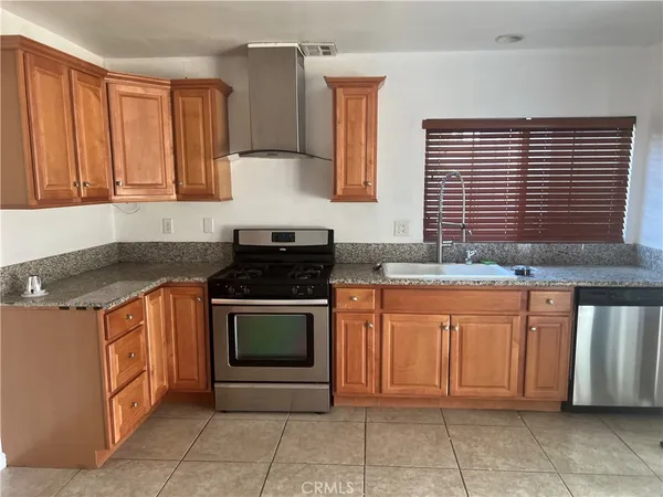 a kitchen with stainless steel appliances granite countertop a stove sink and cabinets