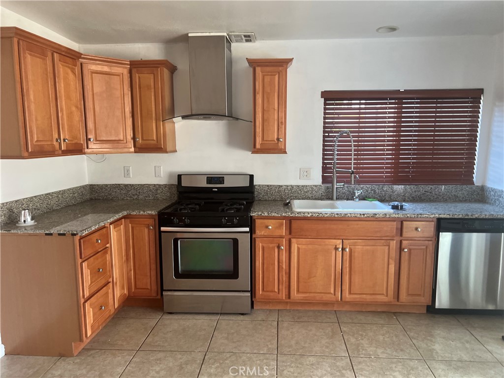 42901 Alep Street Lancaster, CA 93536 - Photo 6 of 17 a kitchen with stainless steel appliances granite countertop a stove sink and cabinets