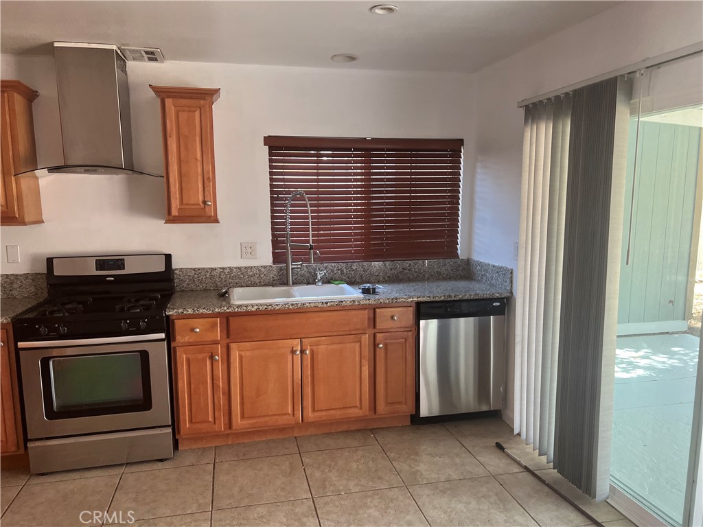 42901 Alep Street Lancaster, CA 93536 - Photo 7 of 17 a kitchen with stainless steel appliances granite countertop a stove and a sink