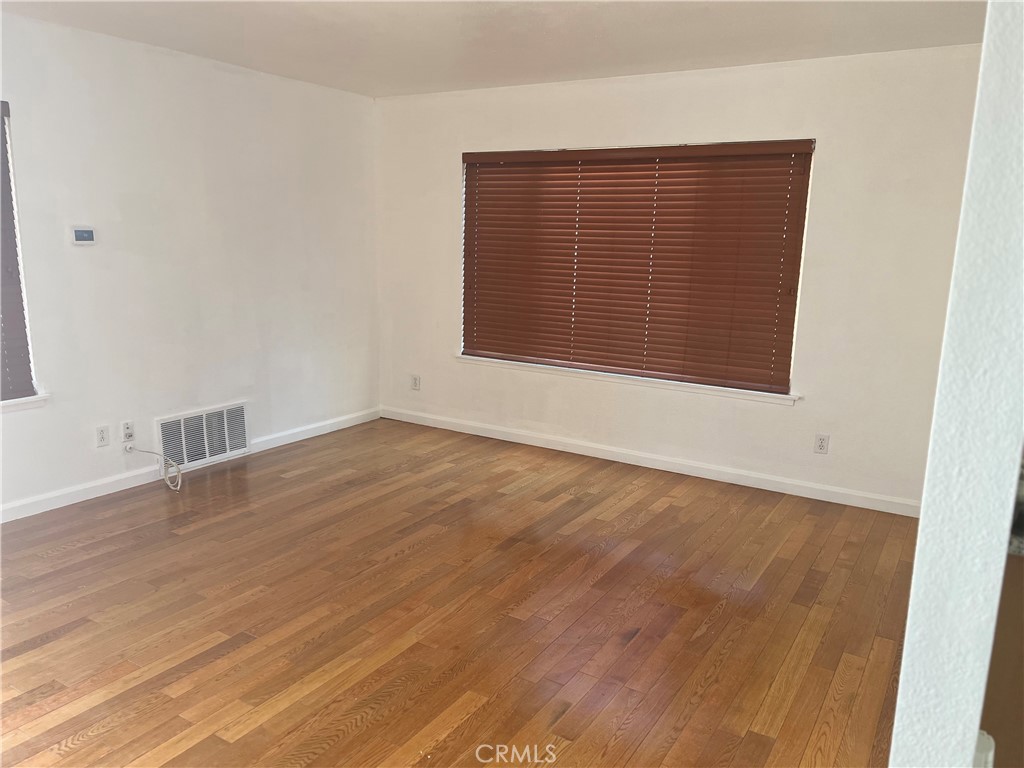 42901 Alep Street Lancaster, CA 93536 - Photo 8 of 17 an empty room with wooden floor and windows